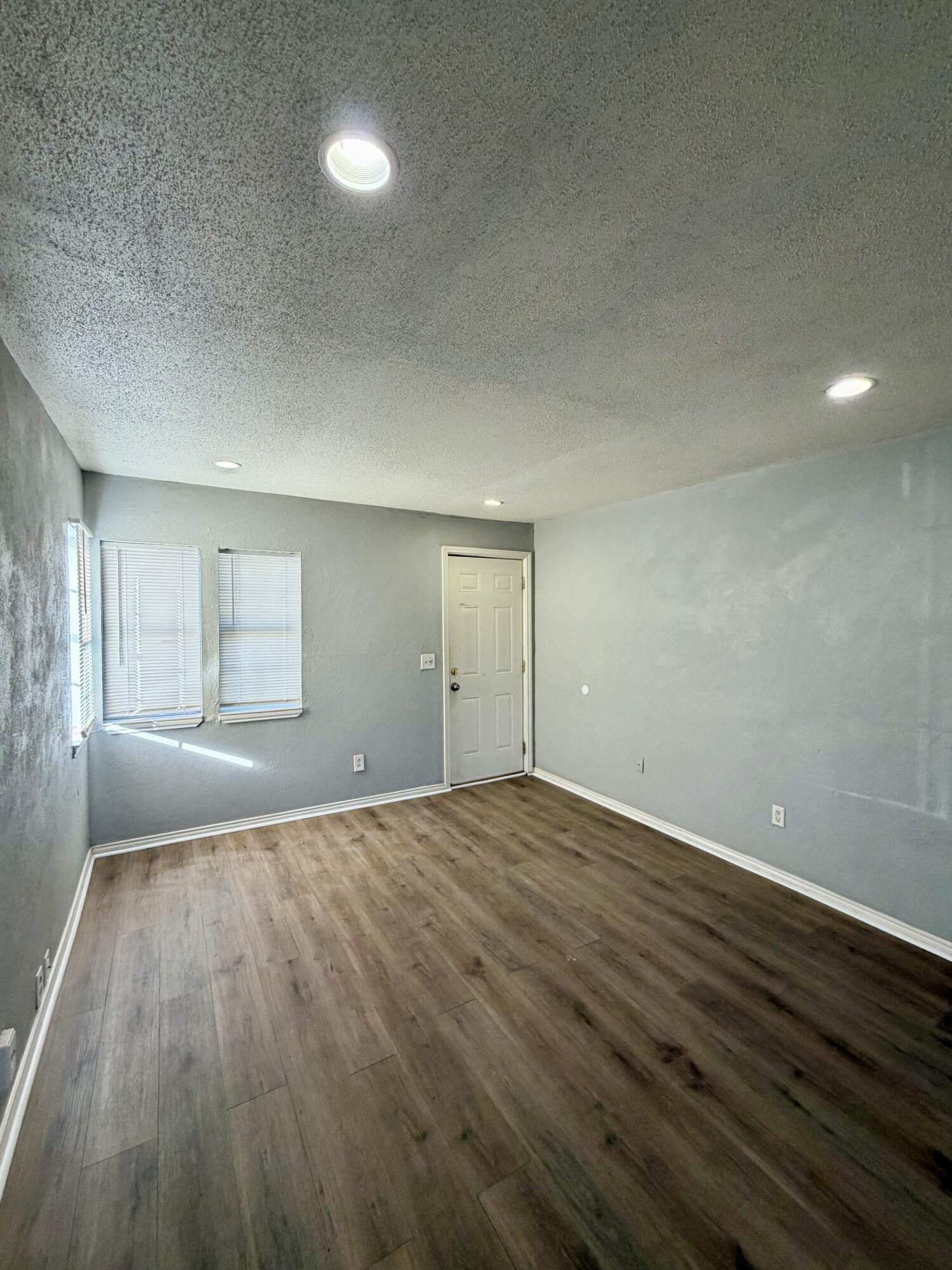 2605 1st Street Lubbock, TX 79415 - Photo 5 of 12 an empty room with wooden floor and windows