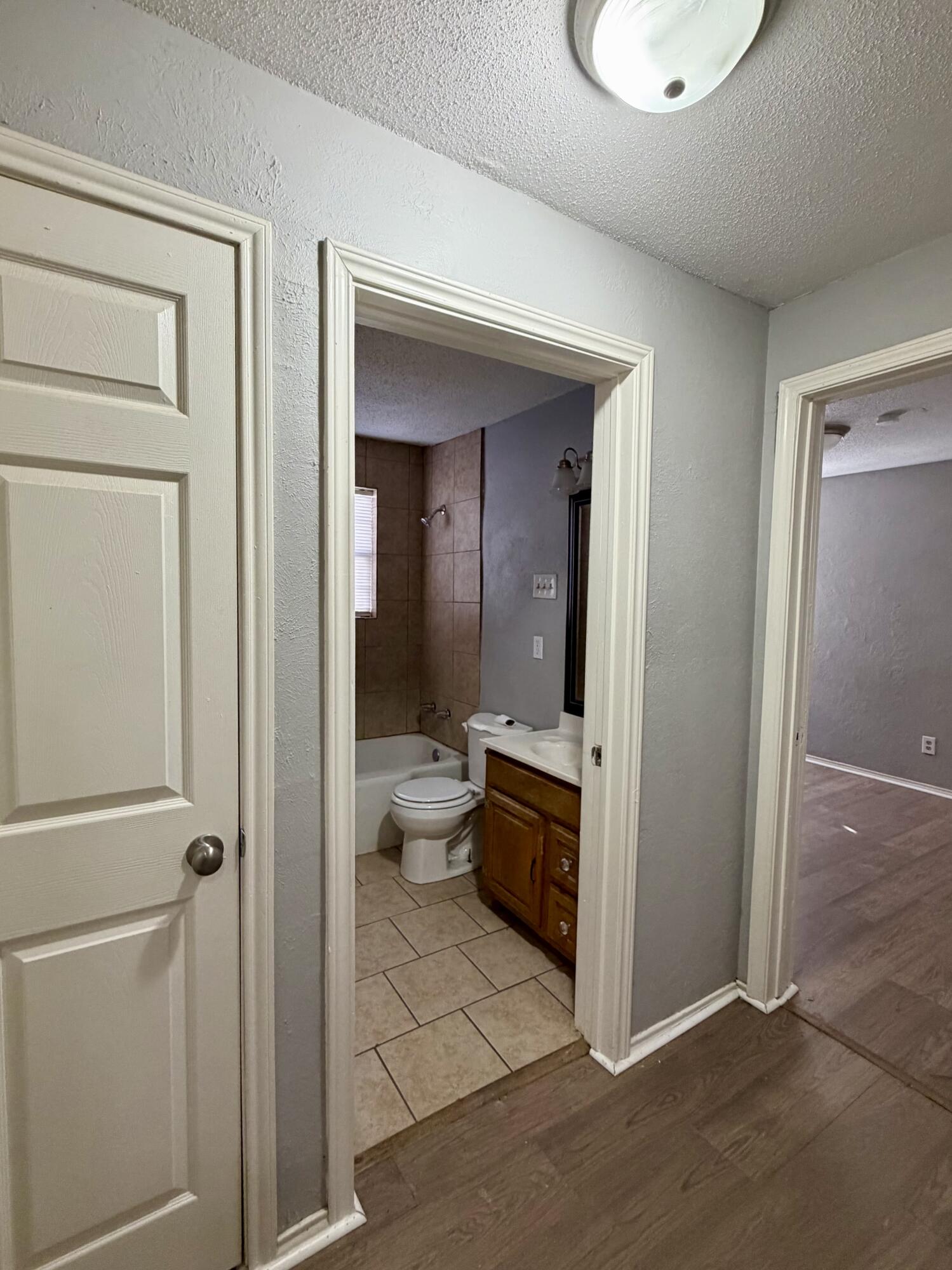 2605 1st Street Lubbock, TX 79415 - Photo 6 of 12 a view of bathroom with a toilet a sink and mirror