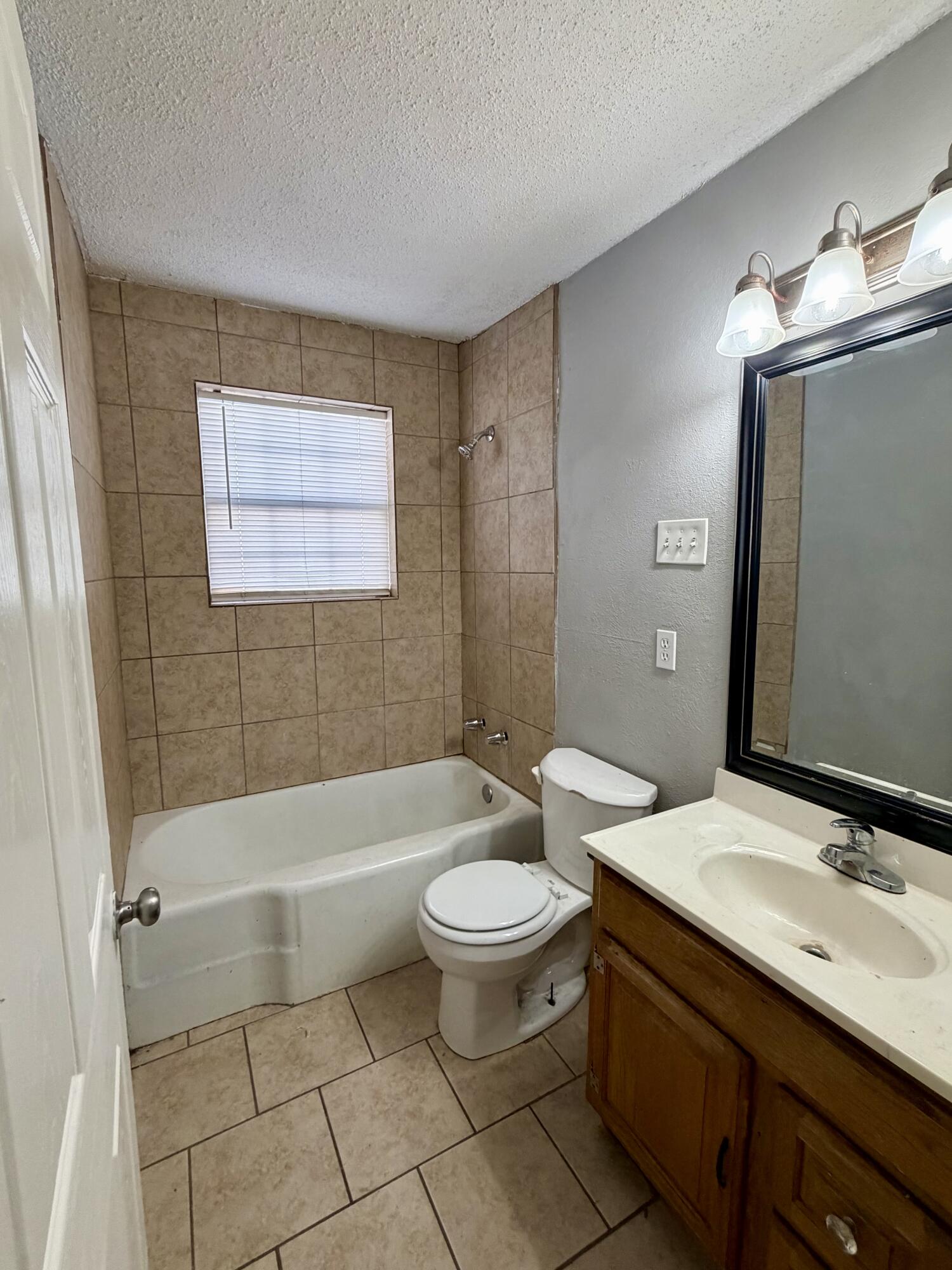 2605 1st Street Lubbock, TX 79415 - Photo 8 of 12 a bathroom with a sink a toilet and shower