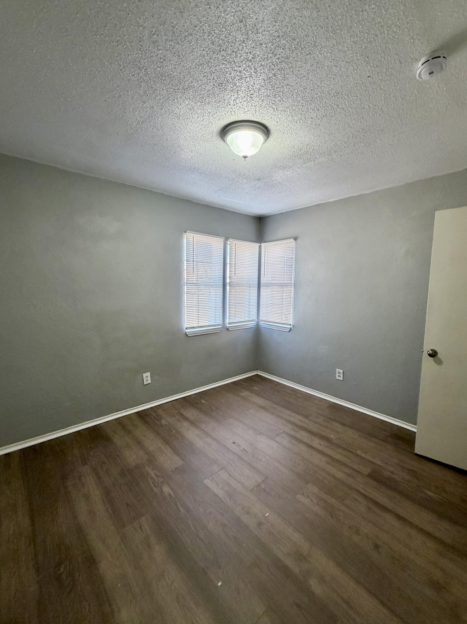 2605 1st Street Lubbock, TX 79415 - Photo 9 of 12 an empty room with wooden floor and windows