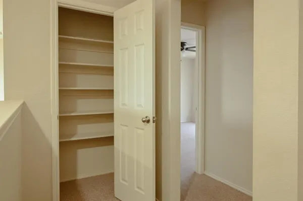 a view of walk in closet with empty racks