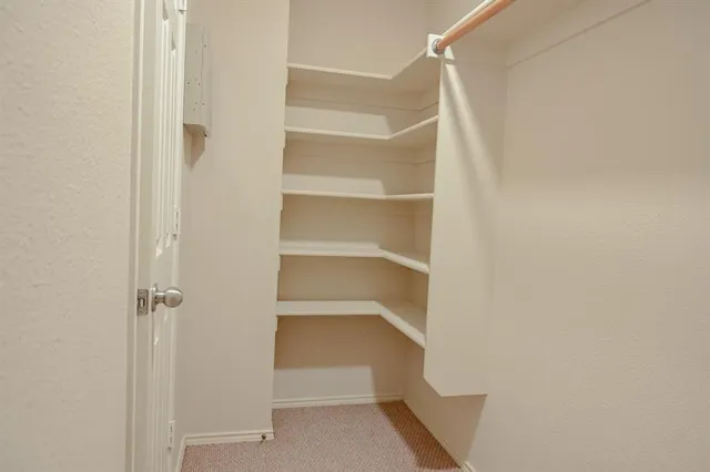 a view of walk in closet with empty racks