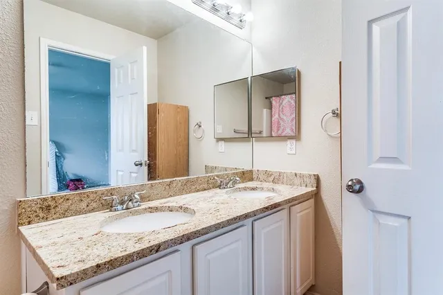 a bathroom with a granite countertop sink and a mirror