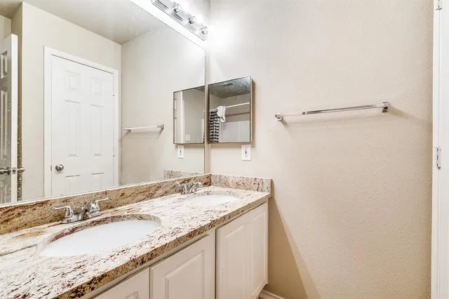 a bathroom with a granite countertop sink and a mirror