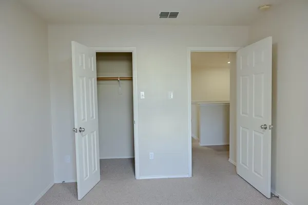 an empty room with closet and wooden door