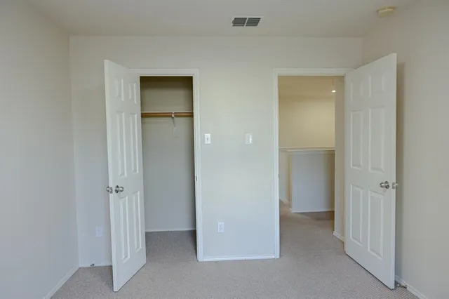 an empty room with closet and wooden door