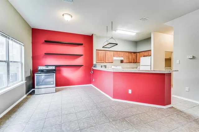 a kitchen with stainless steel appliances granite countertop a red stove top oven a sink with granite countertops and cabinets