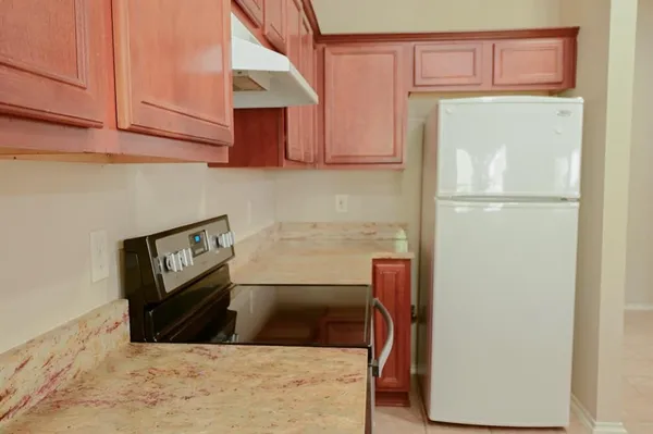 a kitchen with a refrigerator sink and cabinets