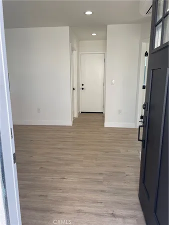 a view of hallway with stainless steel appliances wooden floor