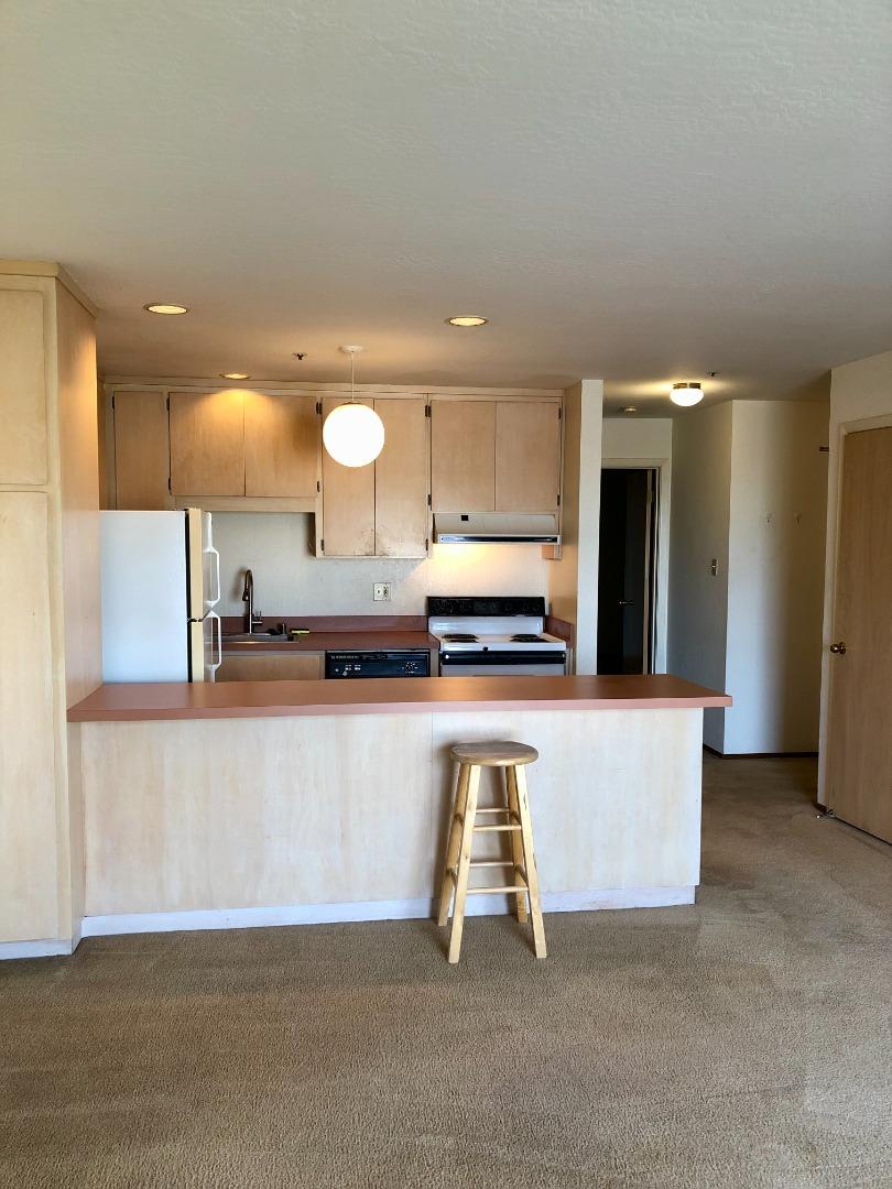 210-4 Broadway Millbrae, CA 94030 - Photo 6 of 15 a kitchen with kitchen island a counter top space a sink and a refrigerator
