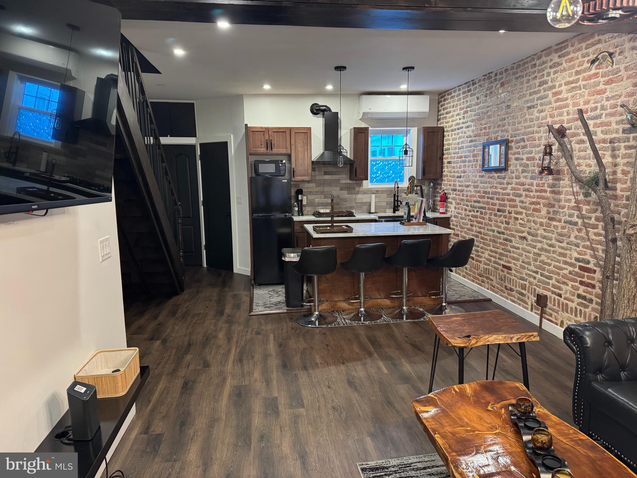 814 Chestnut Street Reading, PA 19602 - Photo 2 of 13 a kitchen with stainless steel appliances kitchen island granite countertop a refrigerator a stove a sink a dining table and chairs with wooden floor