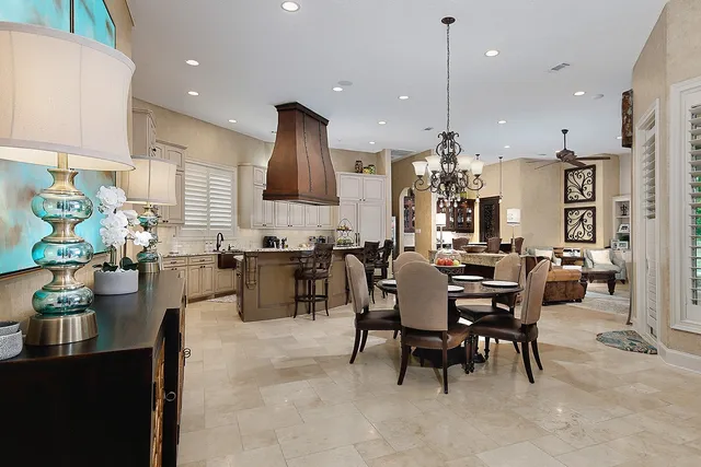 a kitchen with stainless steel appliances kitchen island granite countertop a table and chairs