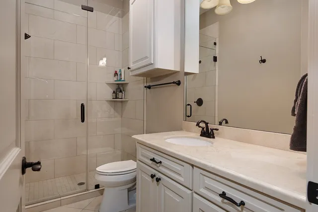 a bathroom with a sink a toilet and shower