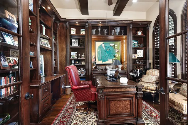 a living room with furniture a bookshelf and a window