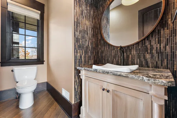a bathroom with a granite countertop sink a toilet and shower