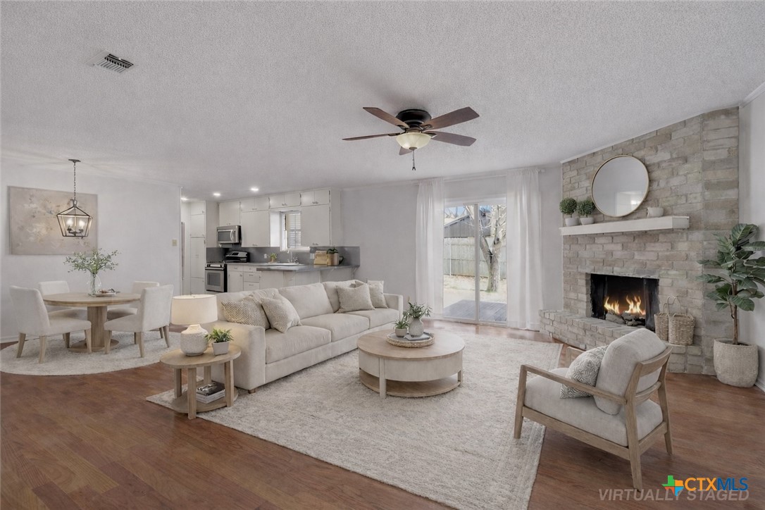 3801 Hickory Road Temple, TX 76502 - Photo 1 of 1 a living room with furniture a fireplace and a dining table with wooden floor