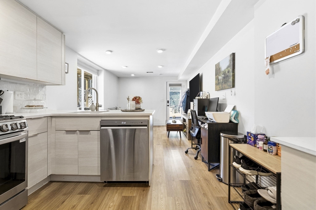 92 Chelsea Street, Unit 1 Boston, MA 02128 - Photo 3 of 14 a kitchen with a sink cabinets and wooden floor