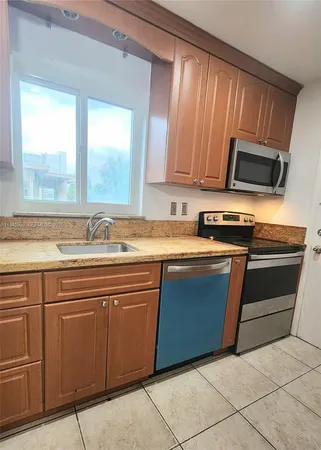 a kitchen with a sink a stove top oven and cabinets