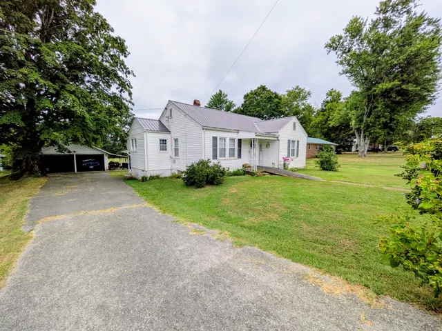 a front view of a house with a garden and trees