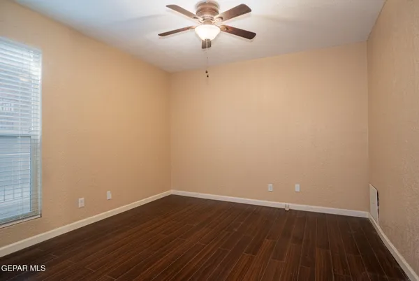 a view of a room with wooden floor and a ceiling fan