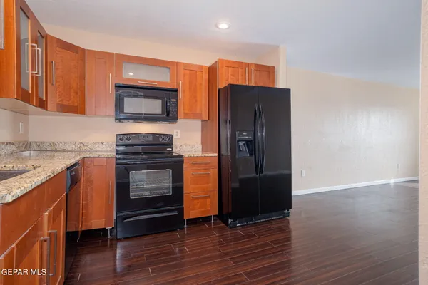 a kitchen with stainless steel appliances granite countertop a refrigerator and a stove top oven