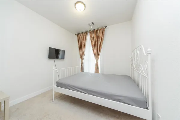 a bedroom with a bed and a flat screen tv