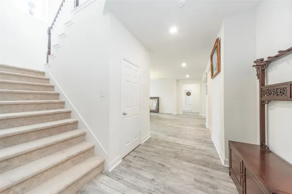 a view of a hallway with wooden floor and staircase
