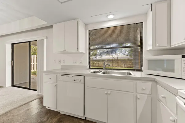 a kitchen with white cabinets and a window