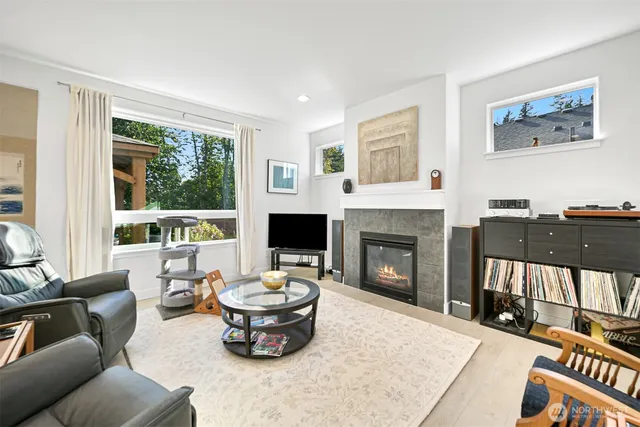a living room with furniture a fireplace and a large window