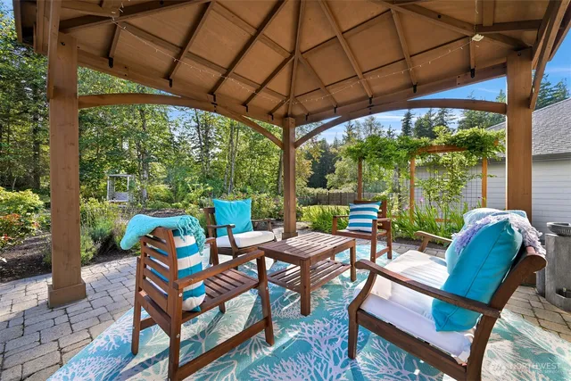 a view of a patio with table and chairs under an umbrella next to a yard