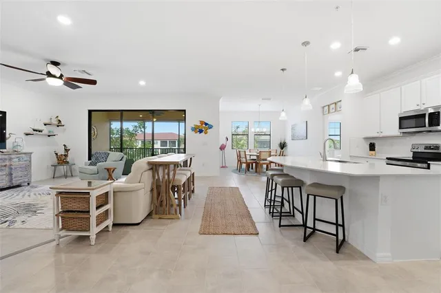 a kitchen with refrigerator a sink and chairs