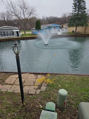 a view of swimming pool with seating area and lake view
