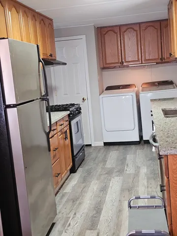 a kitchen with granite countertop a refrigerator and a stove top oven