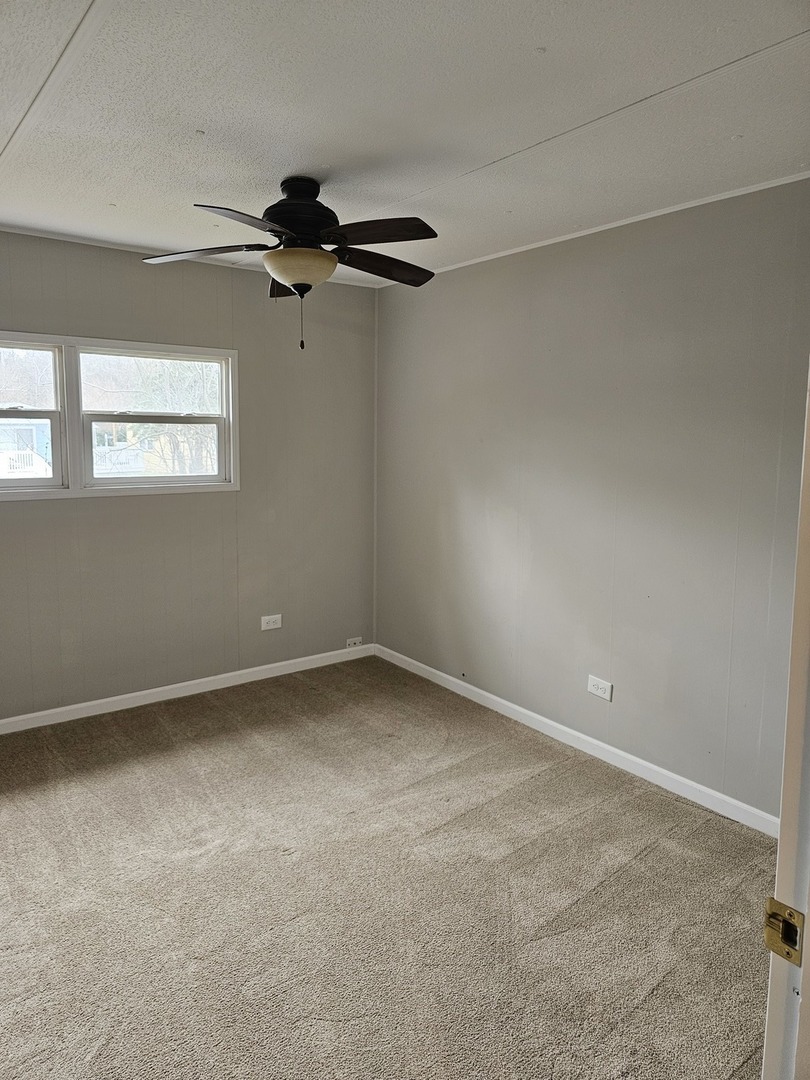 241 Little Peninsula Road Elgin, IL 60123 - Photo 7 of 20 an empty room with a ceiling fan and a window