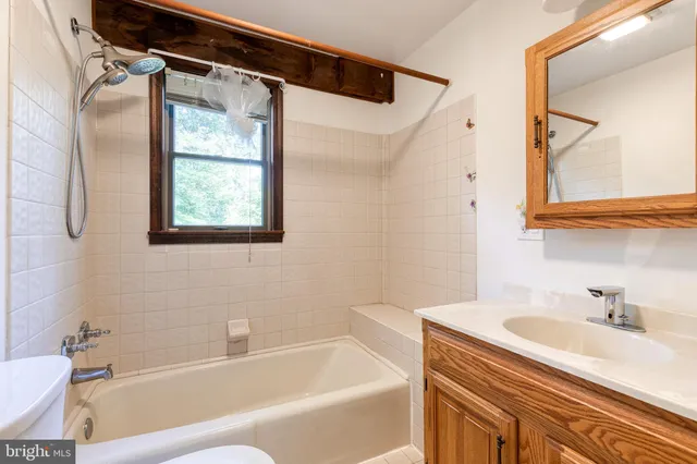 a bathroom with a granite countertop sink and a bathtub