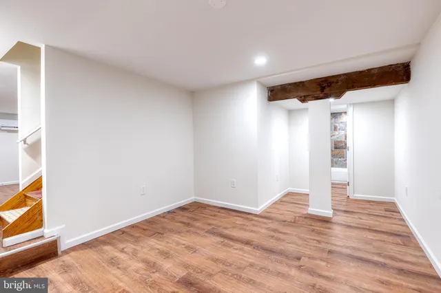 a view of empty room with wooden floor