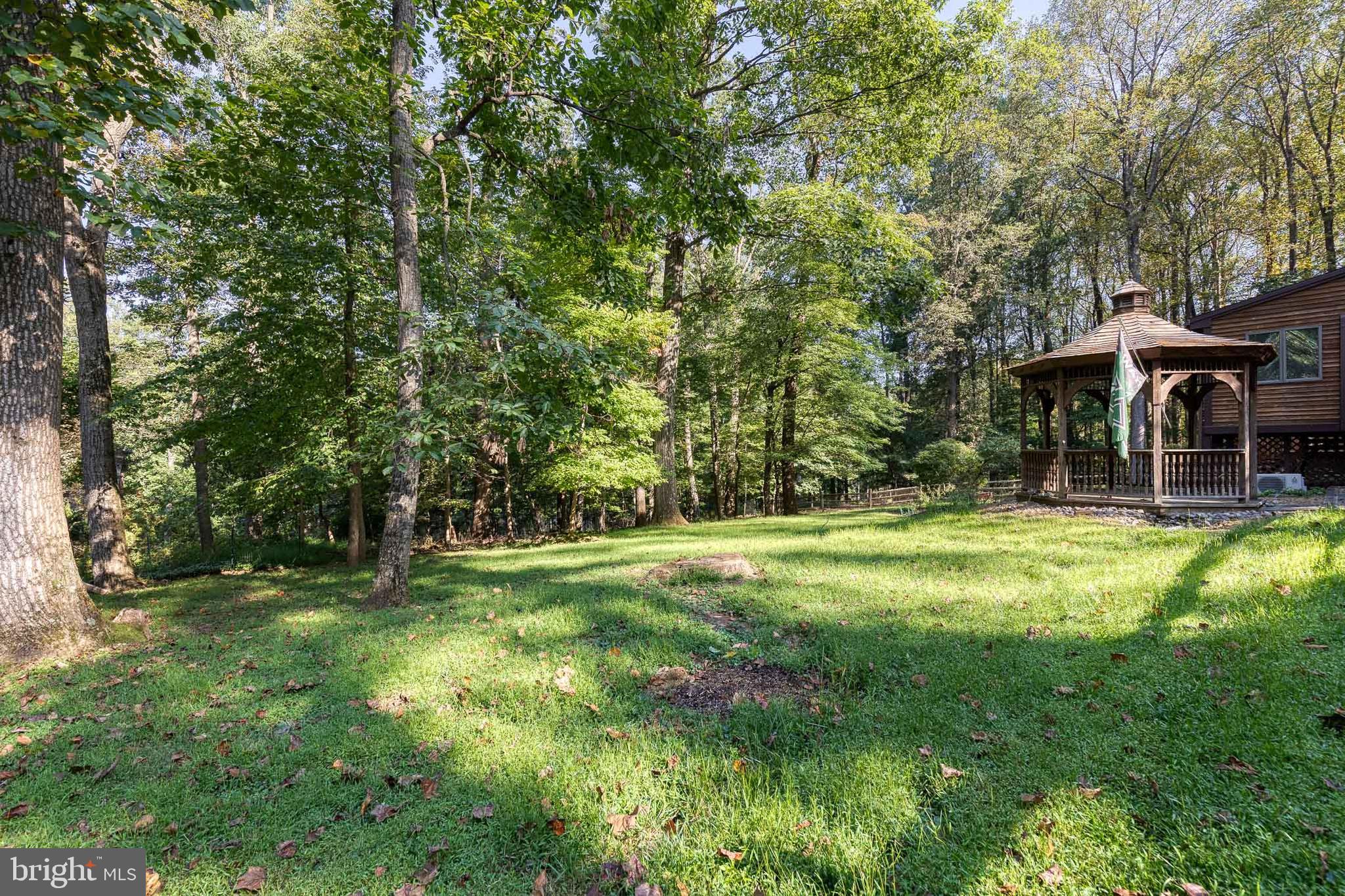12610 Timber Grove Road Reisterstown, MD 21136 - Photo 37 of 39 a backyard of a house with table and chairs under an umbrella
