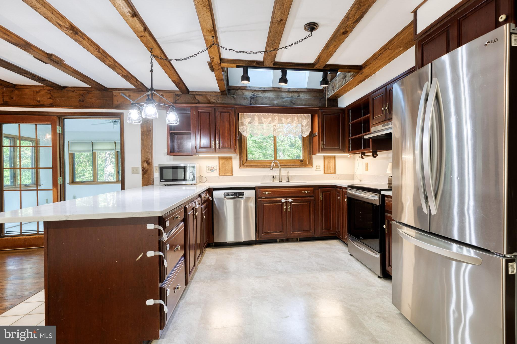 12610 Timber Grove Road Reisterstown, MD 21136 - Photo 9 of 39 a kitchen with stainless steel appliances granite countertop a refrigerator a sink dishwasher a stove with white cabinets and wooden floor