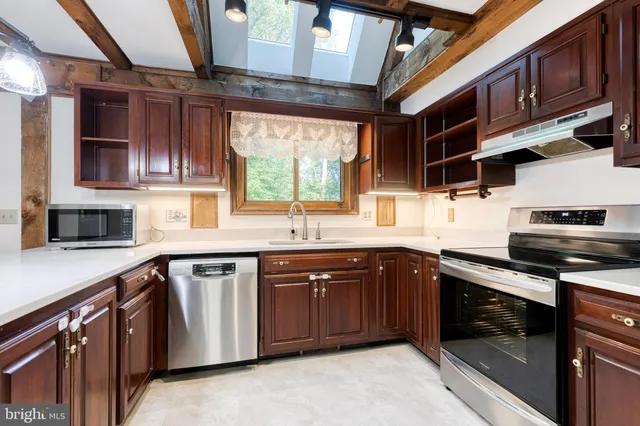 a kitchen with stainless steel appliances granite countertop a sink stove and cabinets