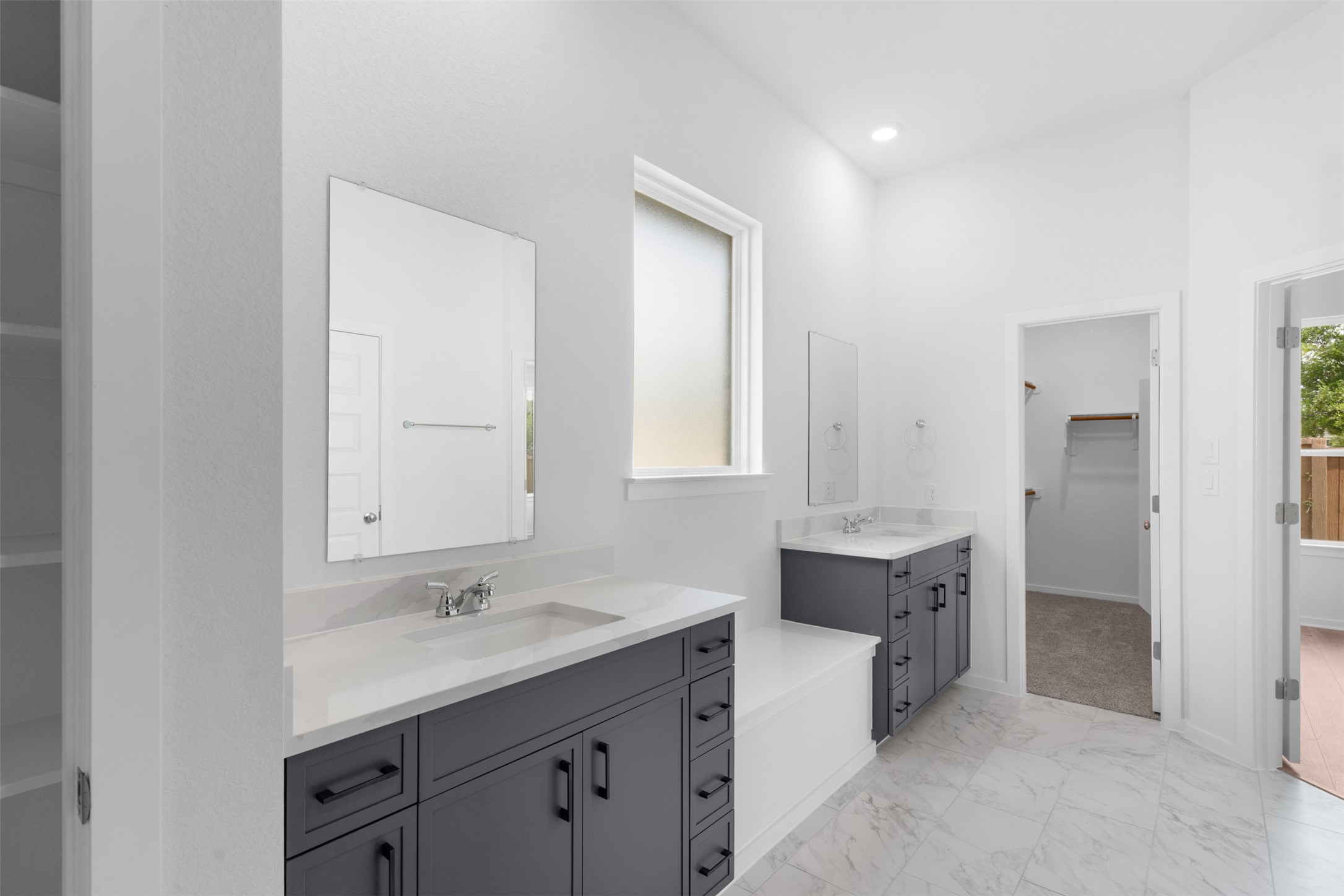316 Ridgewell Loop Georgetown, TX 78633 - Photo 11 of 25 Spacious bathroom featuring dual vanities with quartz countertops, modern dark cabinetry, and tiled flooring