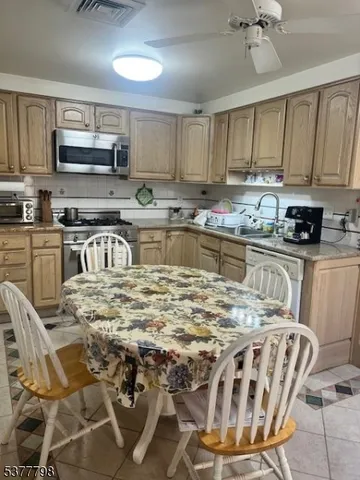 a kitchen with stainless steel appliances granite countertop a stove a sink a microwave and a refrigerator