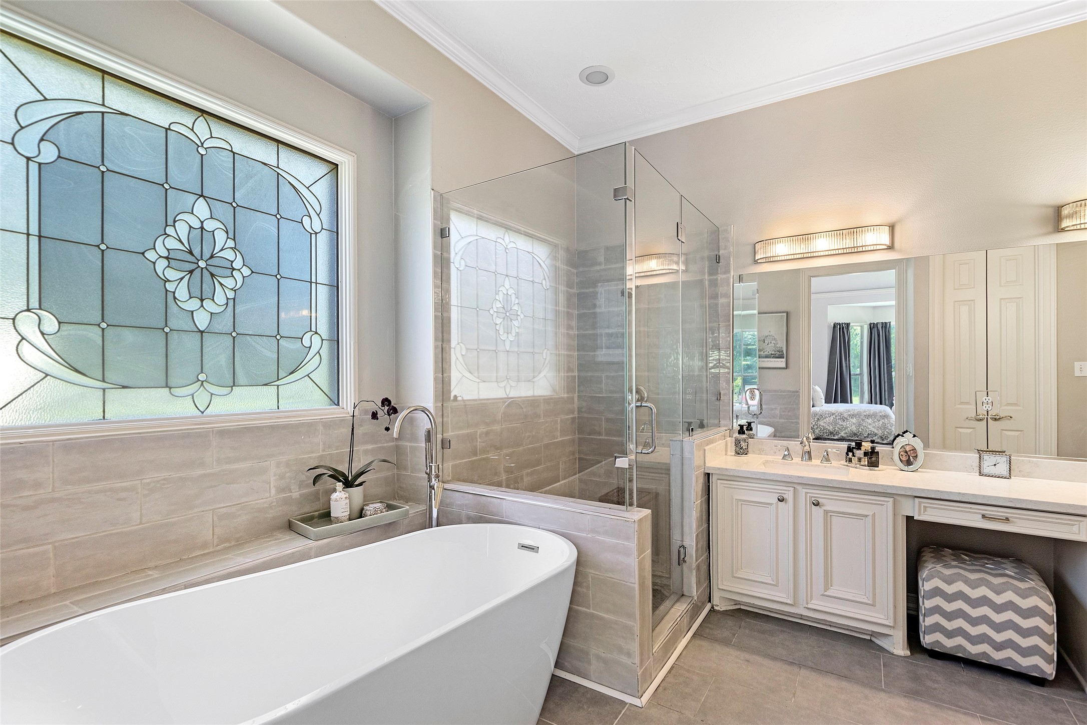 6530 Treaschwig Road, Unit 1 Spring, TX 77373 - Photo 19 of 32 a bathroom with a double vanity sink a large mirror a bathtub and next to a window