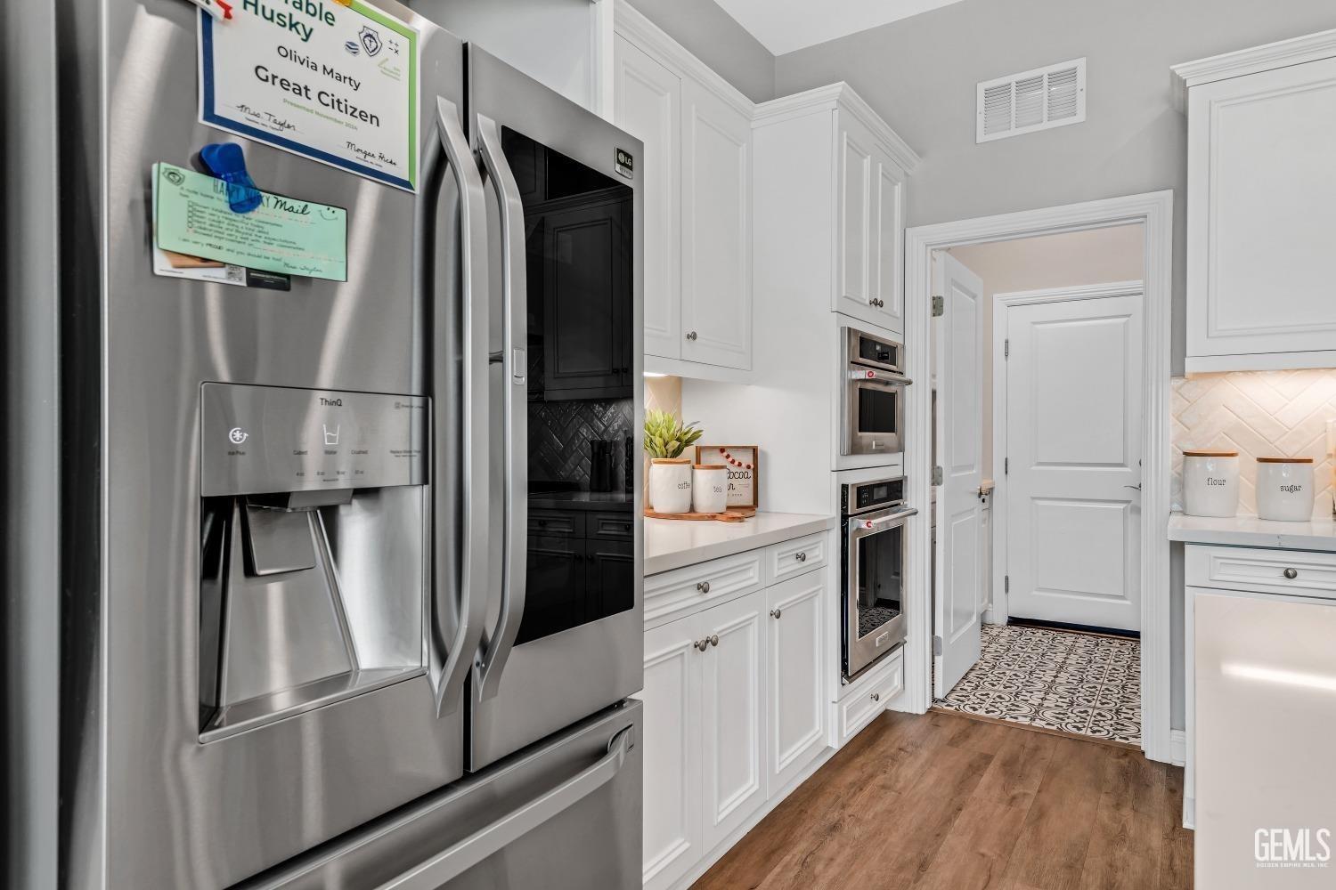 Undisclosed Address Bakersfield, CA 93311 - Photo 25 of 52 a kitchen with stainless steel appliances a refrigerator a stove and white cabinets