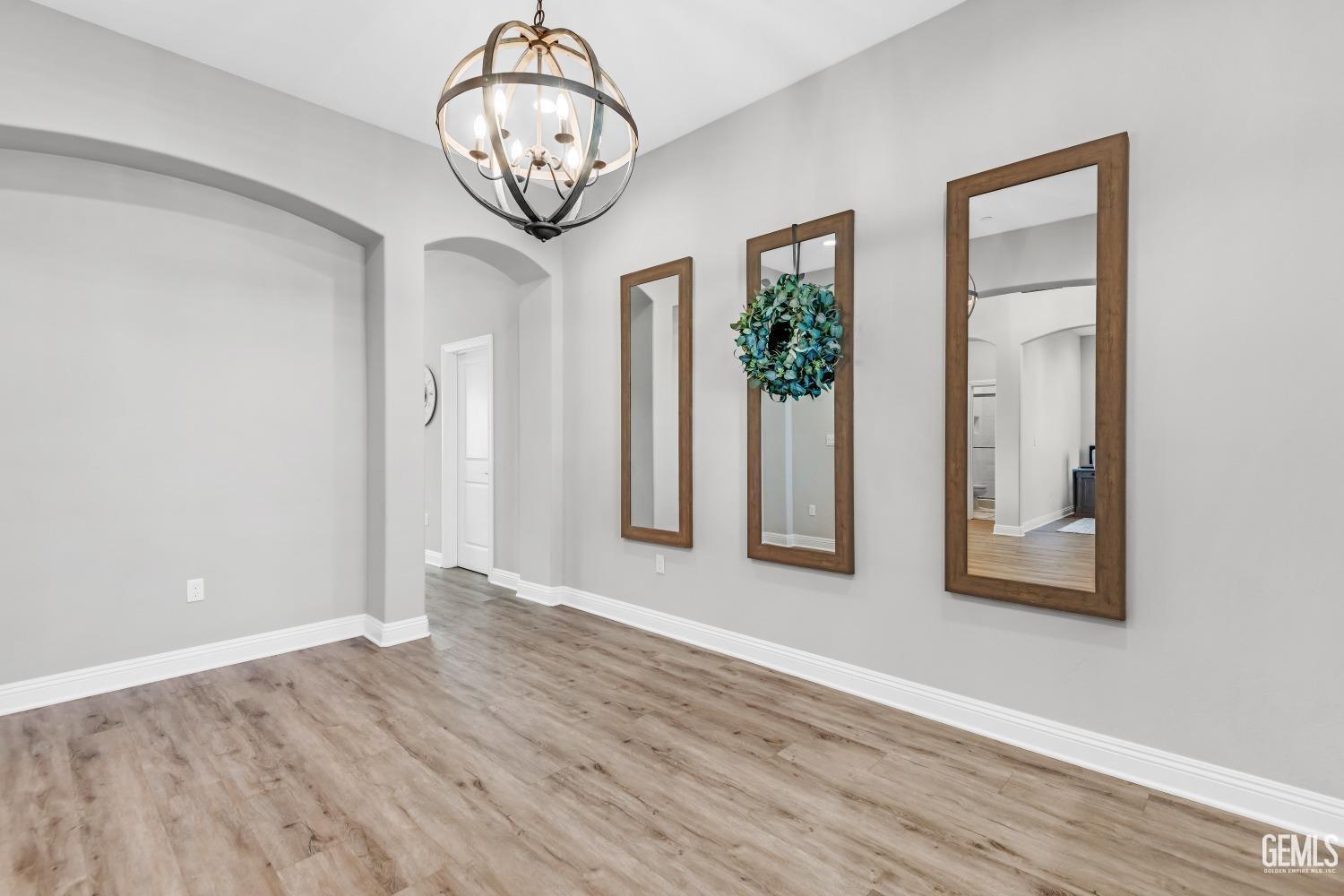 Undisclosed Address Bakersfield, CA 93311 - Photo 31 of 52 an empty room with wooden floor mirror and windows