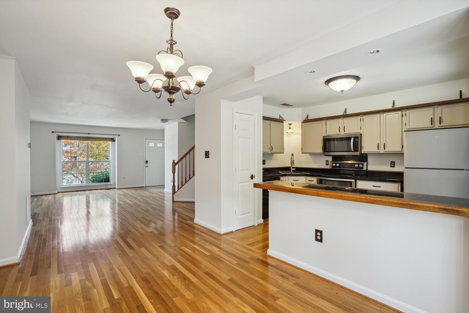 9205 Ridgefield Circle Frederick, MD 21701 - Photo 4 of 19 a kitchen with stainless steel appliances granite countertop a refrigerator a sink dishwasher a stove and white countertops with wooden floor