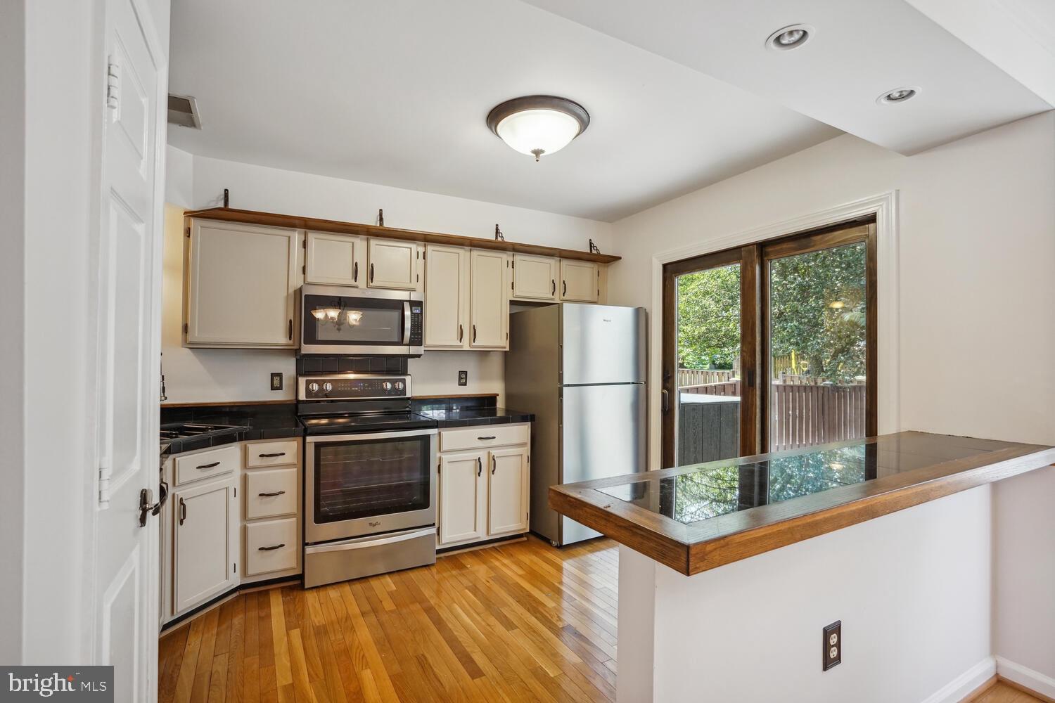 9205 Ridgefield Circle Frederick, MD 21701 - Photo 6 of 19 a kitchen with stainless steel appliances granite countertop a stove a refrigerator and a microwave