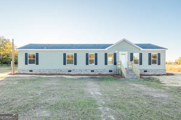 a view of a house with a backyard