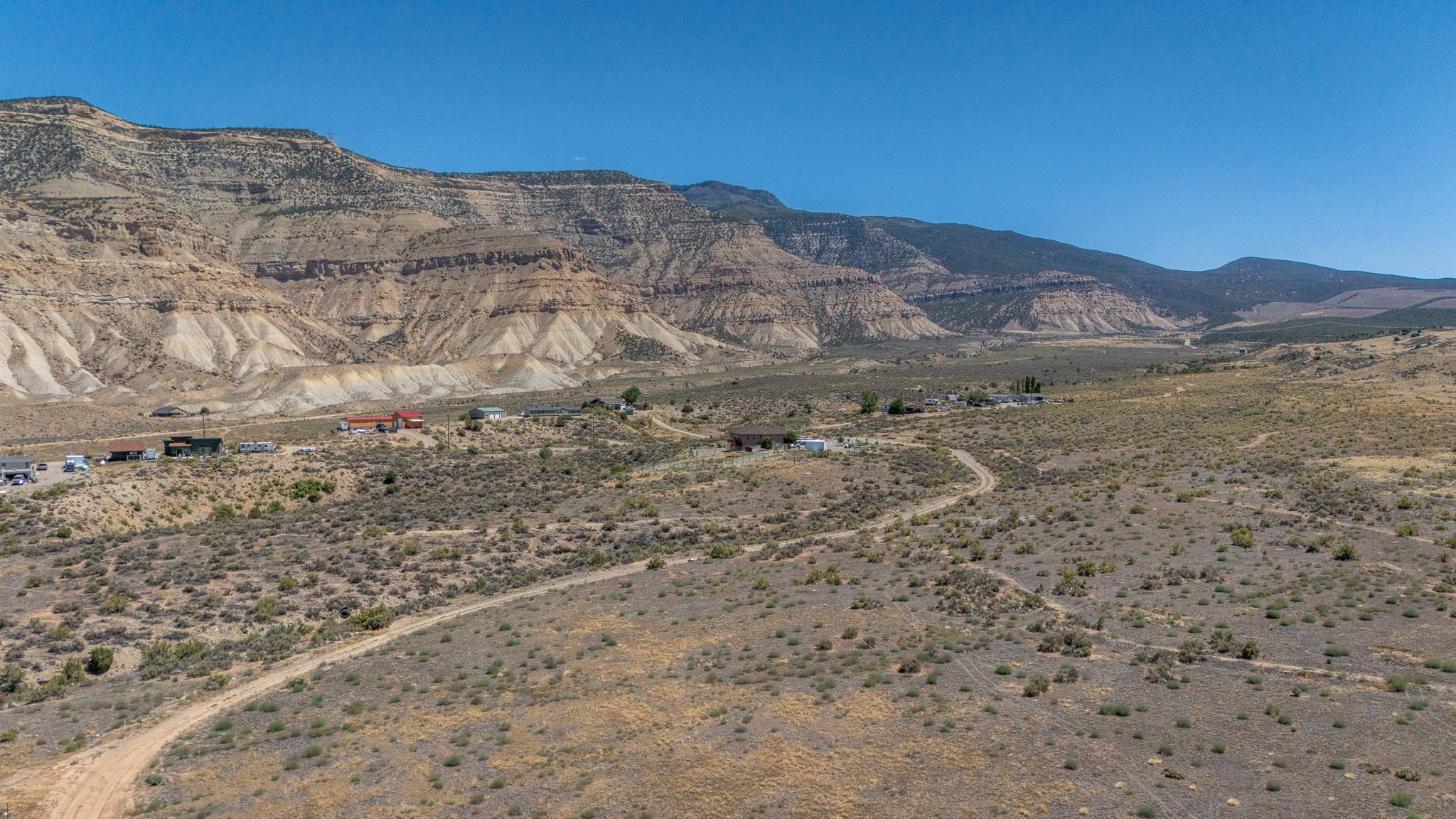 589 39 Road Palisade, CO 81526 - Photo 11 of 40 a view of a dry yard with mountains in the background
