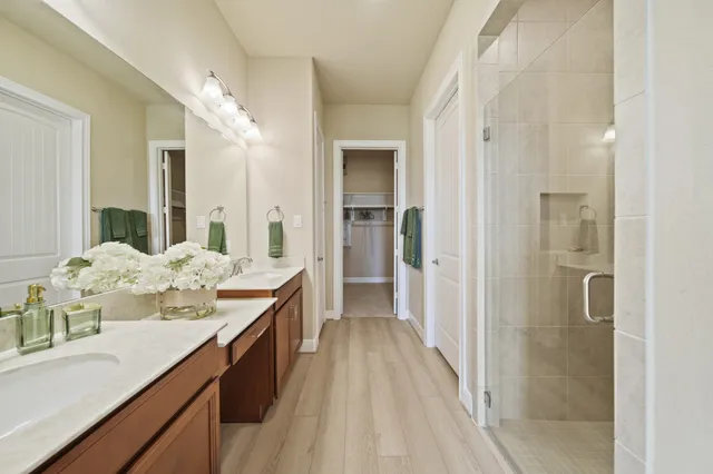 a bathroom with a granite countertop sink a mirror and a shower