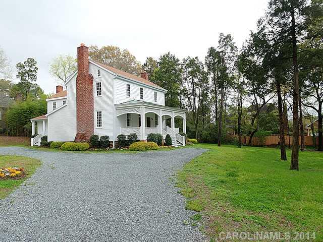 6701 Providence Road Charlotte, NC 28270 - Photo 2 of 13 a view of a white house with a big yard and large trees